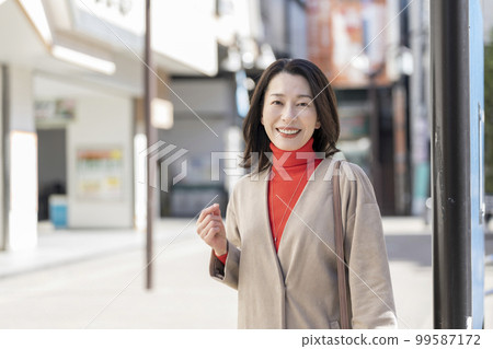 A woman in her late 40s smiling at the camera 99587172