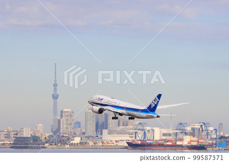 Passenger plane taking off and rising with Tokyo in the background 99587371