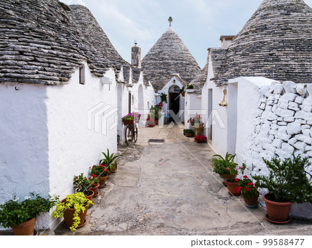 Typical alley of the village of Alberobello with traditional trulli houses, Apulia region, southern Italy 99588477