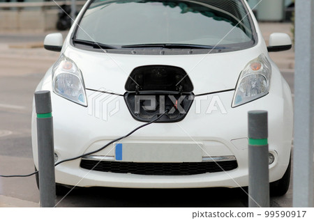 Charging modern white electric car on the street. Power cable pump plug in charging power to electric vehicle EV car. car fueling station connected power cable alternative sustainable eco energy. Charging modern white electric car on the street. Power cable pump plug in charging power to electric vehicle EV car. car fueling station connected power cable alternative sustainable eco energy. 99590917