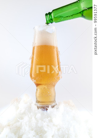 Pouring draft beer into a glass. A glass of beer and snow. Cool beer. Pouring draft beer into a glass. A glass of beer and snow. Cool beer. 99591377