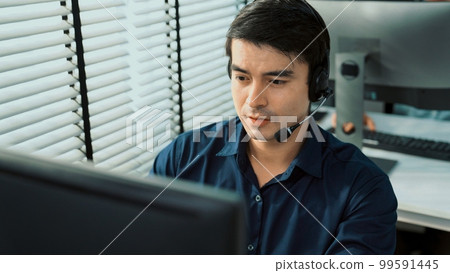Young competent asian male call center agent working in the office. 99591445