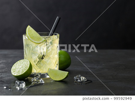 Gimlet Kamikaze cocktail in crystal glass with lime slice and ice on black background. Gimlet Kamikaze cocktail in crystal glass with lime slice and ice on black background. 99592949