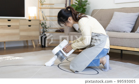 Beautiful woman vacuuming the floor and carpet in her living room, Big cleaning in the house, Removes germs, Housewife cleaning, Keeping her home clean, Domestic hygiene. Beautiful woman vacuuming the floor and carpet in her living room, Big cleaning in the house, Removes germs, Housewife cleaning, Keeping her home clean, Domestic hygiene. 99593005
