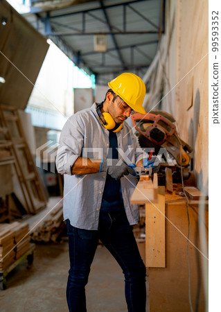 Caucasian wood working or carpenter man use electrical saw to work with timber in factory workplace 99593352