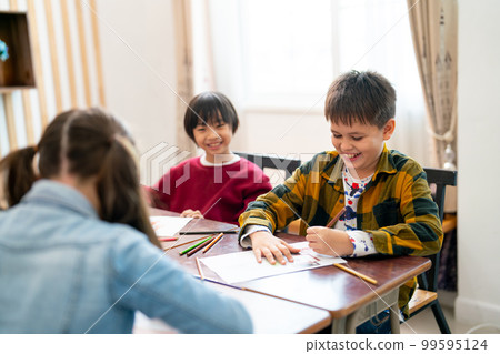 Little Asian boy look happy with smiling and look to his friend draw and paint the picture in class Little Asian boy look happy with smiling and look to his friend draw and paint the picture in class 99595124