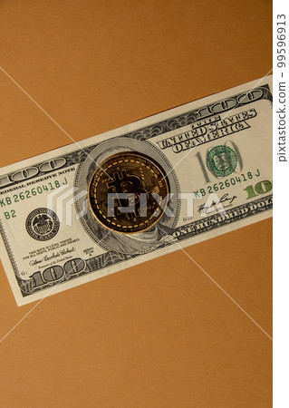 Bitcoin gold coin on bills of 100 dollars American currency. Bitcoin mining trading concept. BTC golden money spinning around. Worldwide virtual internet Cryptocurrency or crypto digital payment Bitcoin gold coin on bills of 100 dollars American currency. Bitcoin mining trading concept. BTC golden money spinning around. Worldwide virtual internet Cryptocurrency or crypto digital payment 99596913