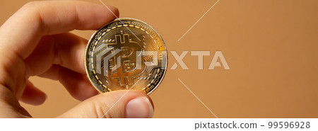 Female hands holding Bitcoin gold coin. Bitcoin mining trading concept. BTC golden money spinning around. Worldwide virtual internet Cryptocurrency or crypto digital payment system 99596928