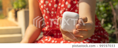 Unrecognizable young woman showing wireless headphones. Copy space for your text. Audio healing, sound therapy wellness rituals, positive mental health habits listening podcast self discovery Unrecognizable young woman showing wireless headphones. Copy space for your text. Audio healing, sound therapy wellness rituals, positive mental health habits listening podcast self discovery 99597033