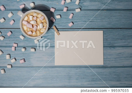 Empty greeting or invitation card mock up with white cup of coffee and marshmallows on wooden blue background. Blank paper copy space for your text. Valentines day, Happy fathers mothers day, Womens Empty greeting or invitation card mock up with white cup of coffee and marshmallows on wooden blue background. Blank paper copy space for your text. Valentines day, Happy fathers mothers day, Womens 99597035