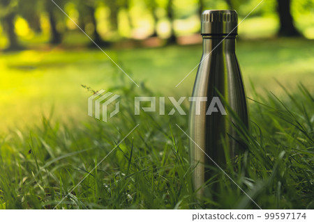 Water bottle. Reusable steel thermo water bottle on green grass. Sustainable lifestyle. Plastic free zero waste free living. Go green Environment protection Water bottle. Reusable steel thermo water bottle on green grass. Sustainable lifestyle. Plastic free zero waste free living. Go green Environment protection 99597174
