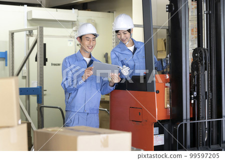 Warehouse worker having a meeting 99597205