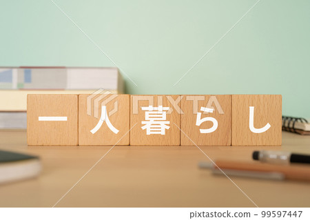 A desk with a block written as living alone 99597447