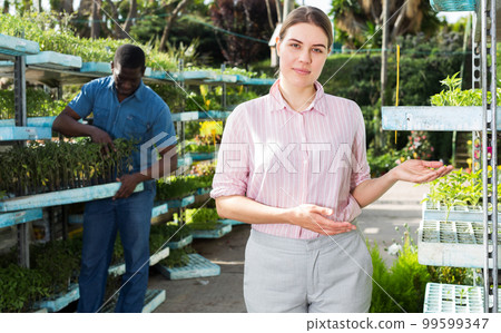 Female owner posing in greenhouse Female owner posing in greenhouse 99599347