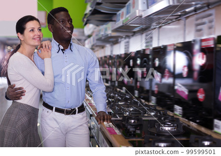 Positive couple chooses cooktop in store Positive couple chooses cooktop in store 99599501