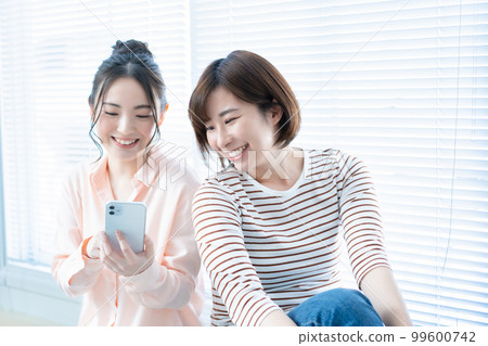 Two women using smartphones Two women using smartphones 99600742
