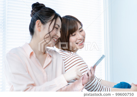 Two women using smartphones Two women using smartphones 99600750