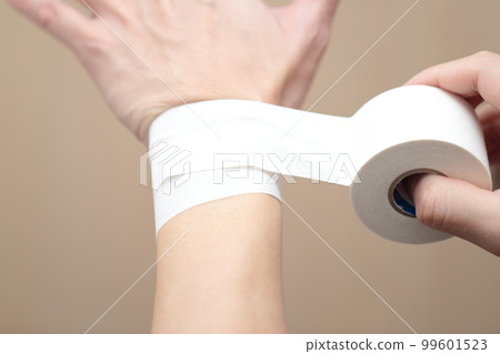 man taping his wrist 99601523