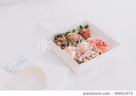 Gift box with clubbing in glaze on white table 99602973