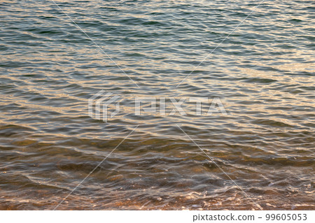 Calm sea surface at sunset 99605053