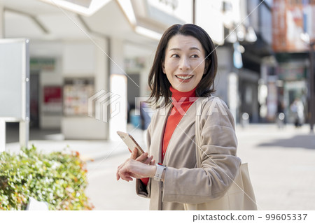 Middle-aged woman with a smartphone 99605337