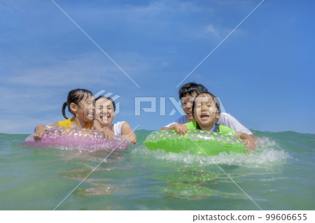 A family of four playing in the summer sea 99606655