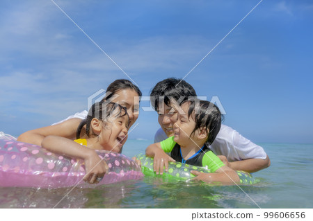A family of four playing in the summer sea 99606656