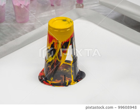 An inverted glass with leaking colored paint. Liquid acrylic creativity, preparatory work. An inverted glass with leaking colored paint. Liquid acrylic creativity, preparatory work. 99608948