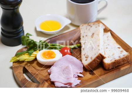Breakfast of bread and ham on a wooden tray Breakfast of bread and ham on a wooden tray 99609468