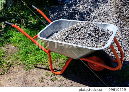 Wheelbarrow with gravel at the construction site 99610259