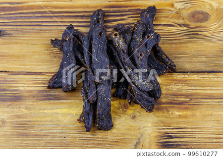 Slices of biltong (South African dried meat) on wooden table Slices of biltong (South African dried meat) on wooden table 99610277