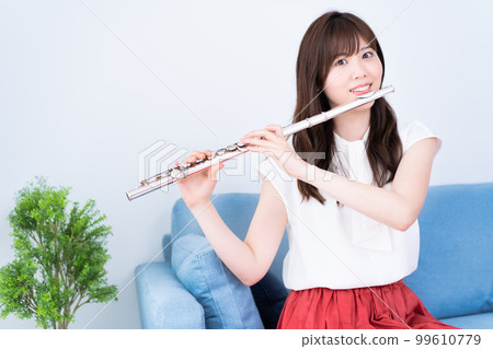 A woman blowing a flute 99610779