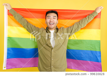 Happy chinese man raising a lgbt rainbow flag Happy chinese man raising a lgbt rainbow flag 99610828