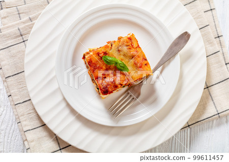 portion of Lasagna on white plate, top view 99611457