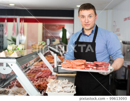 Butcher working behind counter 99613093