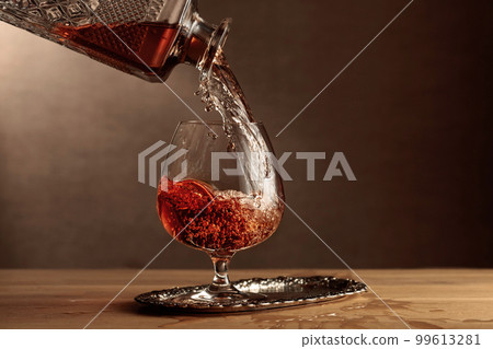 Brandy is poured into a snifter glass. 99613281