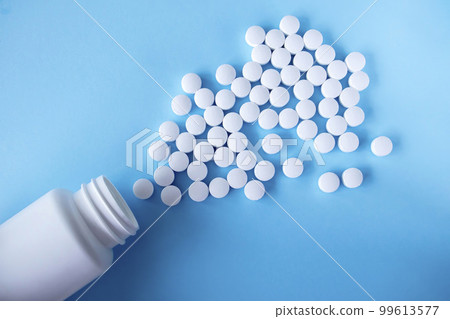 White round tablets, supplements with a can on a blue background. Magnesium vitamins White round tablets, supplements with a can on a blue background. Magnesium vitamins 99613577