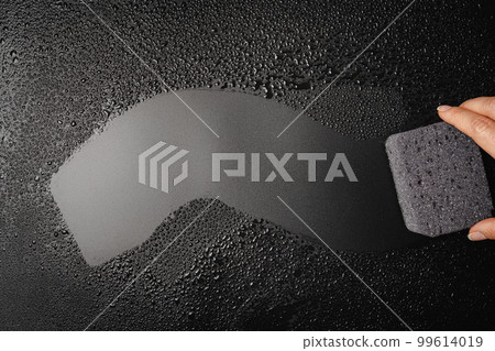 Sponge placed on wet black background 99614019