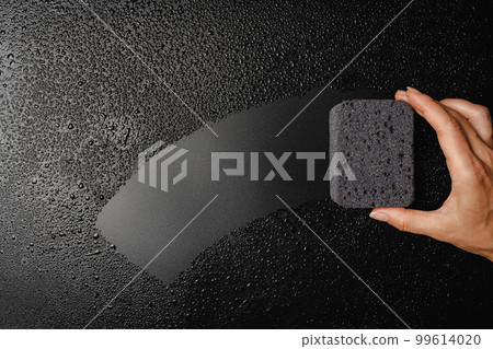 Sponge placed on wet black background 99614020