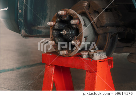 Repair of car brake discs. Hub and brake discs with pads in close-up analysis. Urgent repair in car Repair of car brake discs. Hub and brake discs with pads in close-up analysis. Urgent repair in car 99614176
