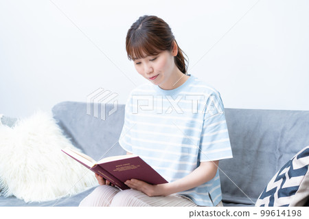 A young lady reading on the sofa A young lady reading on the sofa 99614198