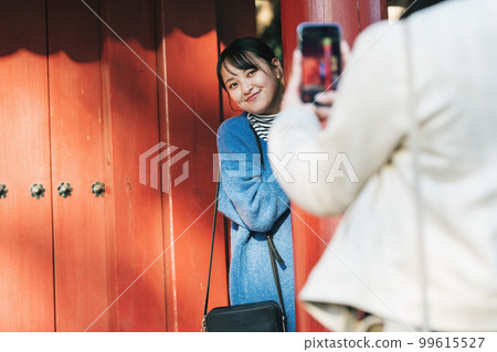 Woman taking pictures while traveling 99615527
