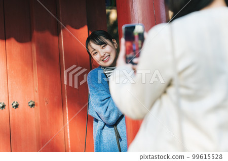 Woman taking pictures while traveling 99615528