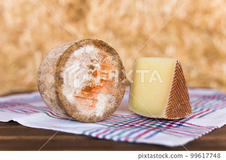 whole head of ripe country cheese and slices on hay whole head of ripe country cheese and slices on hay 99617748