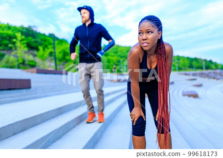 spain woman with afro pigtails crossfit trainer motivating her boyfriend for morning running outdoors in sity 99618173