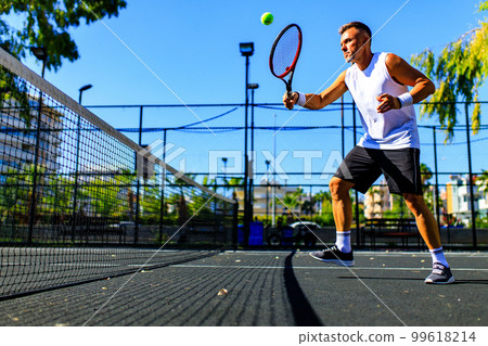 Senior caucasian man playing tennis on court holding tennis racket day light outdoors on fresh air Senior caucasian man playing tennis on court holding tennis racket day light outdoors on fresh air 99618214