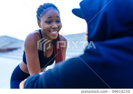 spain woman with afro pigtails crossfit trainer motivating her boyfriend for morning running outdoors in sity spain woman with afro pigtails crossfit trainer motivating her boyfriend for morning running outdoors in sity 99618230