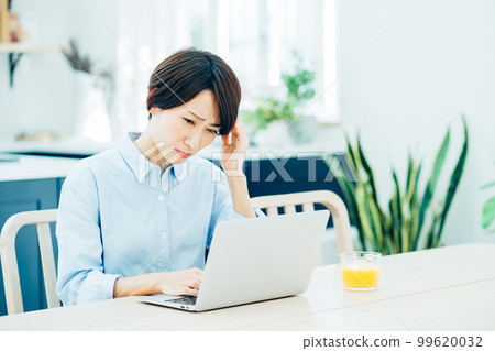 在客廳遠程辦公的中年婦女。 99620032
