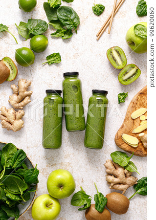 Smoothie. Healthy fresh raw detox spinach smoothie with green apple, kiwi and ginger in a bottles on a table. Healthy diet vegan food full of antioxidants. Top view Smoothie. Healthy fresh raw detox spinach smoothie with green apple, kiwi and ginger in a bottles on a table. Healthy diet vegan food full of antioxidants. Top view 99620060