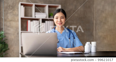Young female doctor sitting and working in her clinic Young female doctor sitting and working in her clinic 99621017